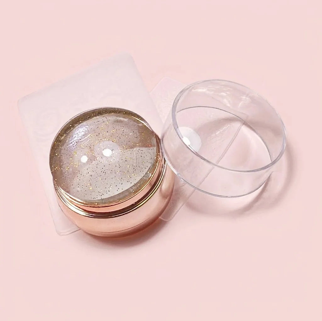 Sello para stamping dorado con cabezal de silicona transparente y tapa protectora.